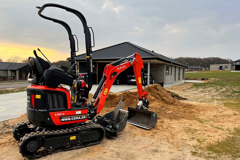Brugt Kubota U10-5 minigraver med tre skovle klar til gravearbejde ved parcelhus